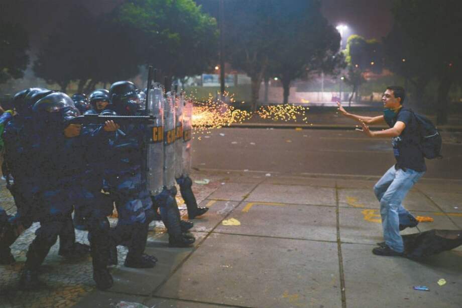 La policía dispara balas de goma contra un manifestante en Río de Janeiro, Brasil. / AFP