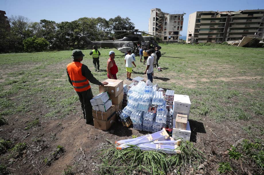 Personas descargan ayudas humanitarias de un helicóptero este lunes, en La Guaira (Venezuela).