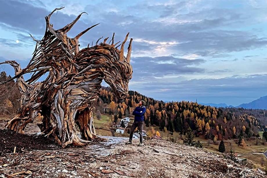 Situado sobre una colina en los bosques italianos de Lavarone, en la provincia norteña de Trento, se alza un enorme dragón alado que, construido por el artista Marco Martalar con la leña de los árboles derribados por el temporal Vaia, custodia los mismos bosques que fueron arrasados en 2018. EFE/Marco Martalar