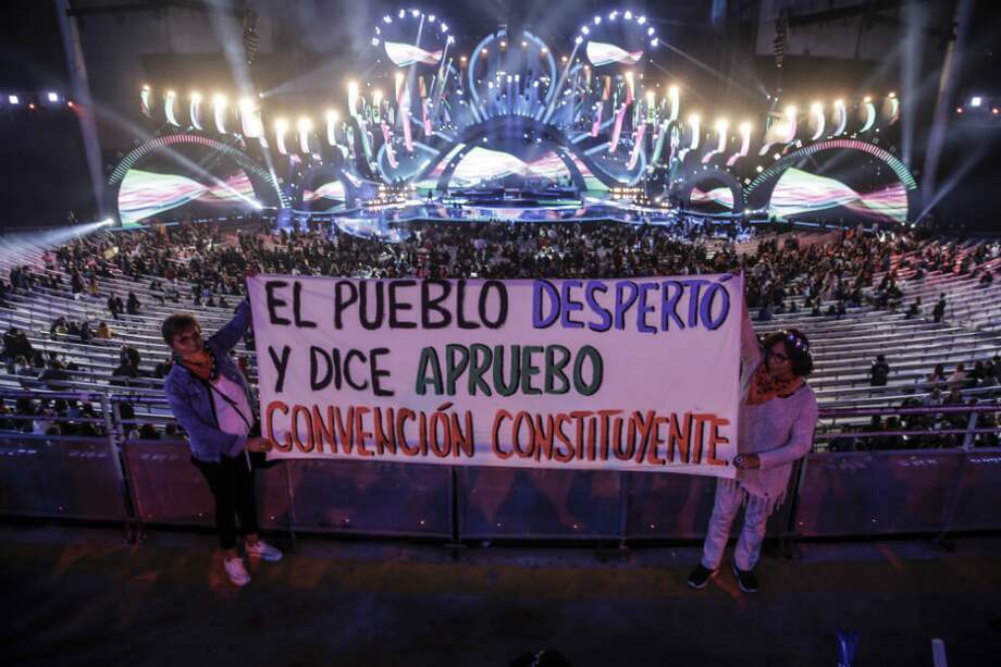 Fanáticos de la cantante chilena Mon Laferte muestran una pancarta que dice "La gente se despertó y dice que aprueba la Convención Constituyente" durante el 61º Festival Internacional de la Canción de Viña del Mar en Viña del Mar en Chile. / AFP