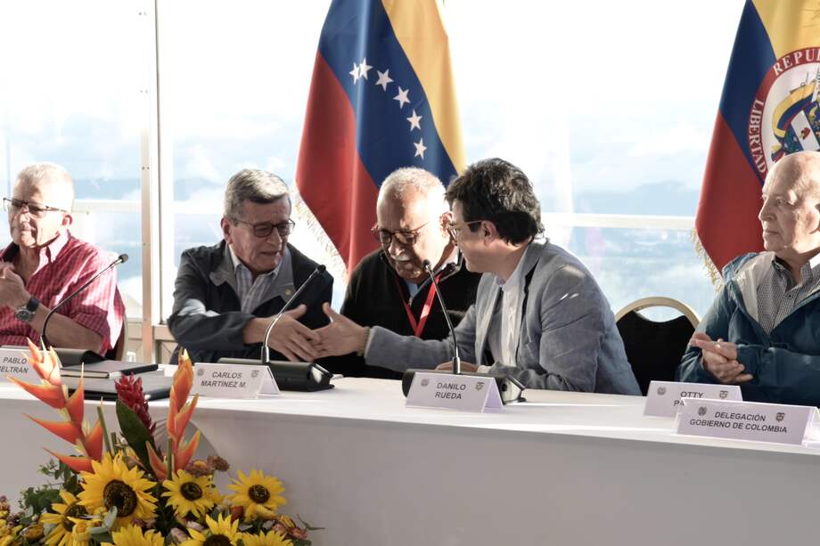 Danilo Rueda y Pablo Beltrán estrechando manos en la instalación de la mesa de negociación, en Caracas.