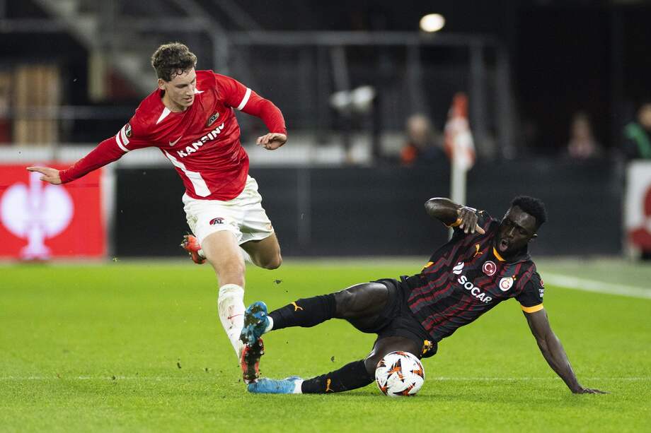 El defensor colombiano Dávinson Sánchez (der.) disputa un balón con Robin van Bommel, del atacante neerlandés del AZ.