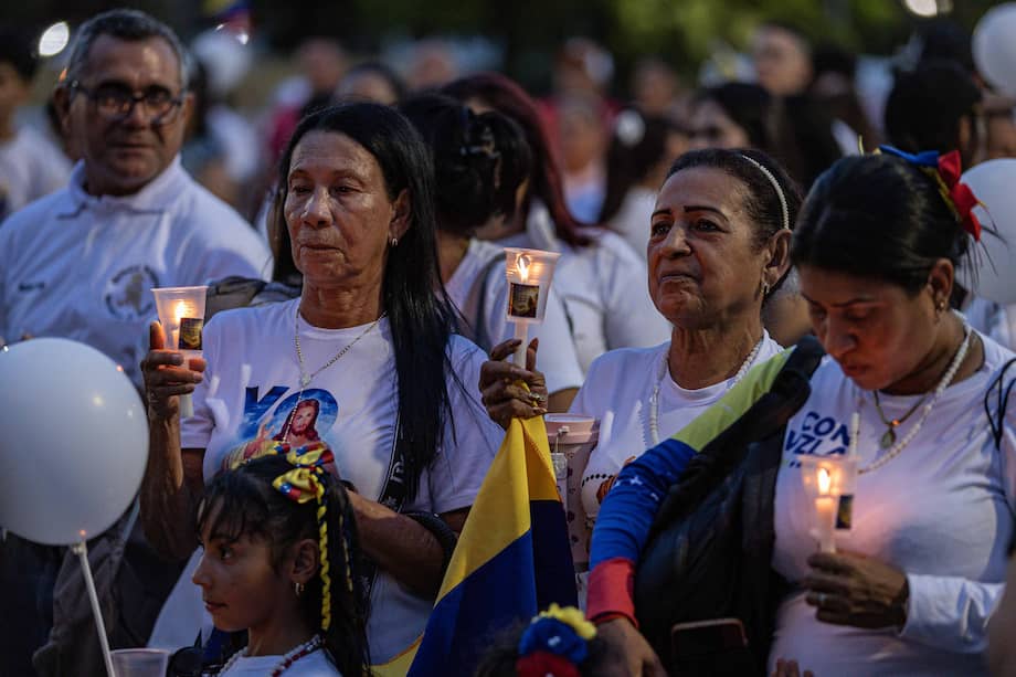 Personas encienden velas durante una misa en memoria de las víctimas del doble terremoto del 24 de junio, este viernes en la Basílica de Nuestra Señora de Chiquinquirá, Maracaibo (Venezuela).