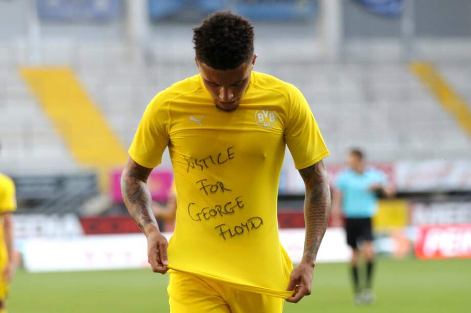 El futbolista inglés de Borussia Dortmund, Jadon Sancho, muestra una camiseta de "Justicia para George Floyd" mientras celebra después de marcar un gol. / AFP