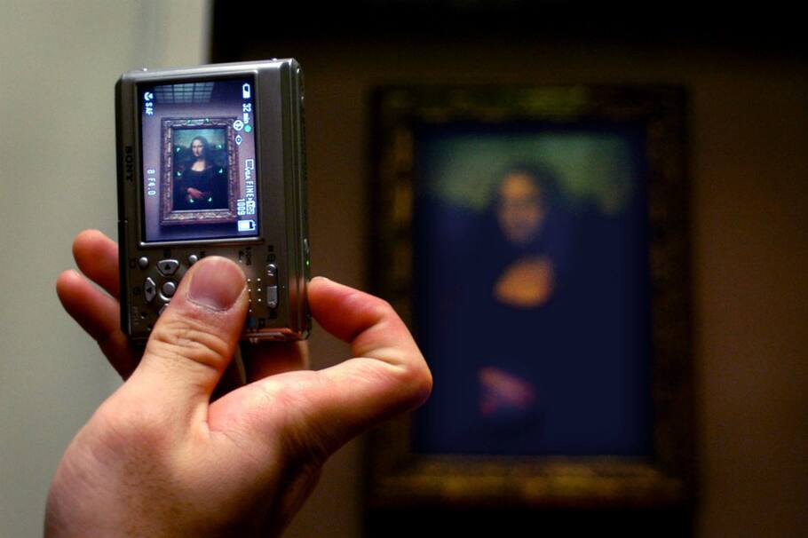 A visitor photographs the 'Mona Lisa' painting at the Louvre Museum in Paris, Wednesday, January 19, 2005. Photographer: Alastair Miller/Bloomberg News. HOLD FOR FEATURE