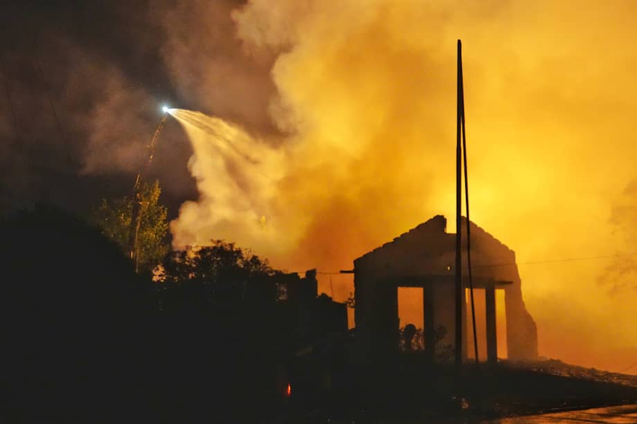 Los bomberos rocían agua en el lugar de la explosión de una fábrica de fuegos artificiales en Liuyang, en la provincia central china de Hunan.