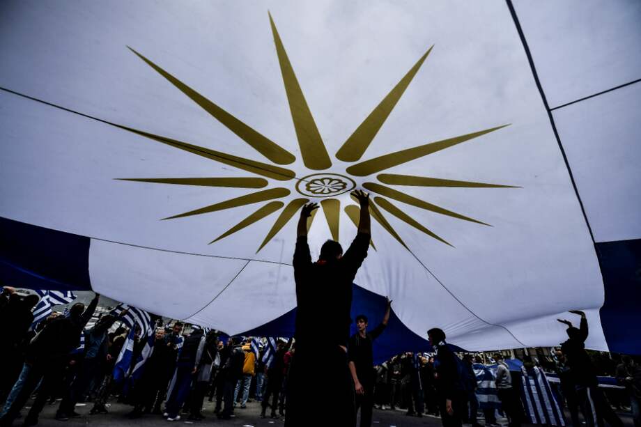Manifestantes sostienen una bandera de la región griega de Macedonia. / AFP