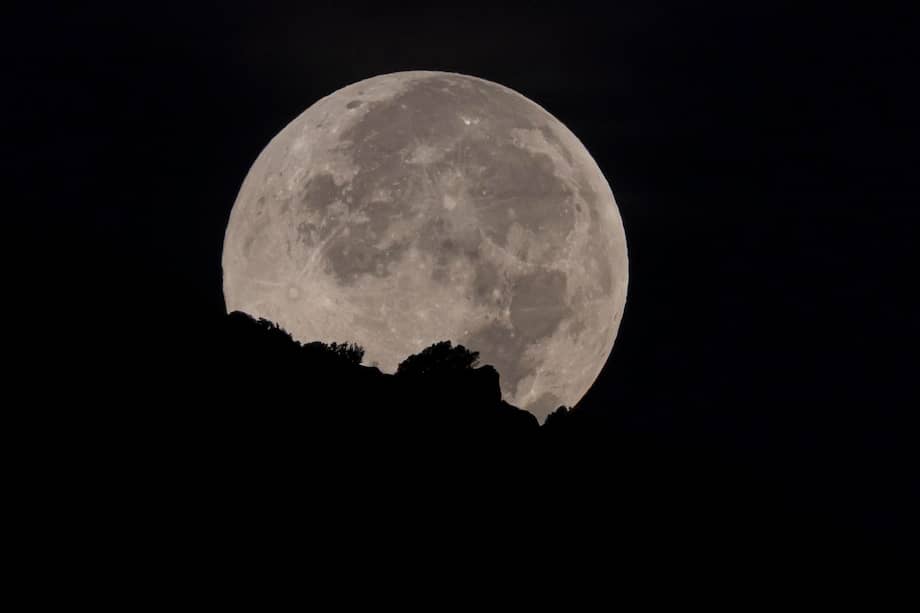 Puesta de la primera luna llena de octubre, también llamada 'luna de cosecha', esta madrugada en el poniente mallorquín. EFE/CATI CLADERA