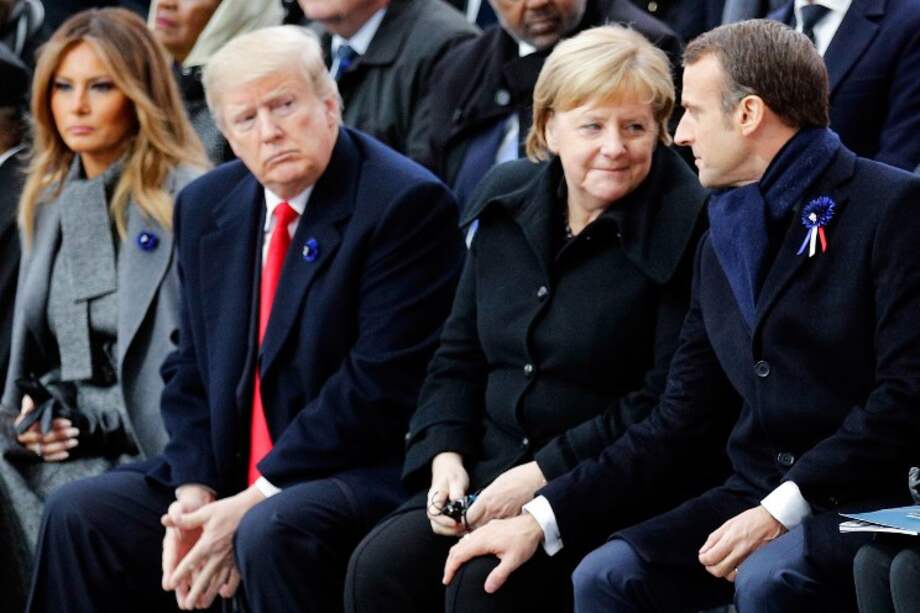El presidente de Estados Unidos, Donald Trump, mira de reojo a Emmanuel Macron y Angela Merkel durante la conmemoración de los 100 años del armisticio. / AFP