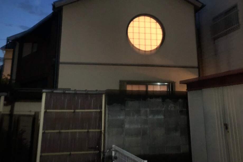 Ventana redonda de madera y papel de arroz en una vivienda de estilo tradicional en Kioto.