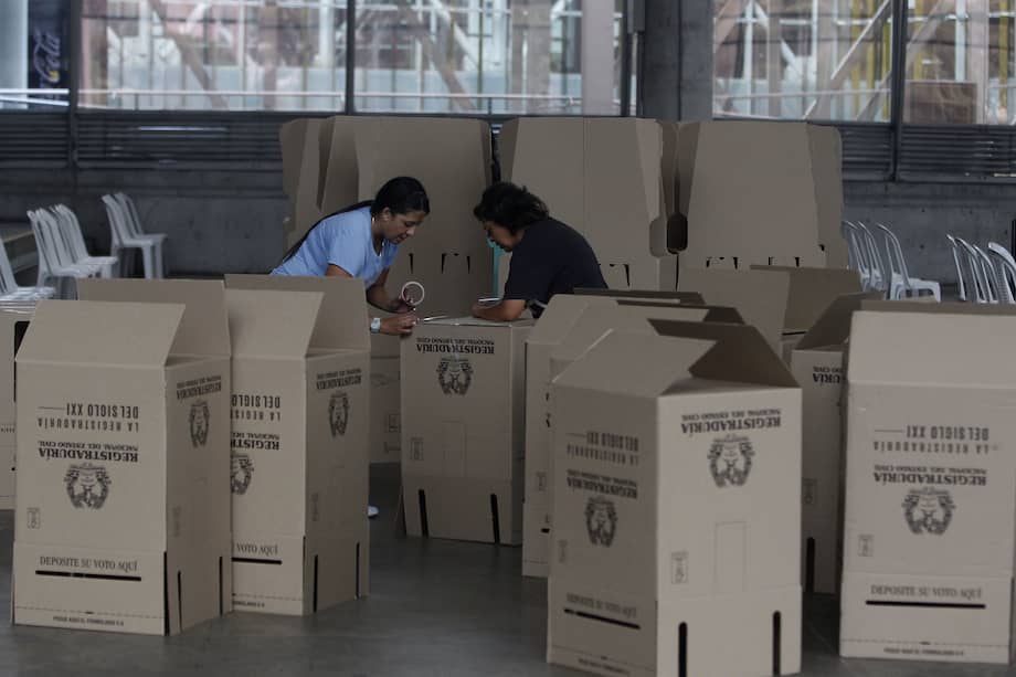 MED108. MEDELLÍN (COLOMBIA), 28/10/2023.- Dos mujeres preparan un puesto de votación hoy, en el recinto de Plaza Mayor en Medellín (Colombia). Este domingo los colombianos elegirán alcaldes, gobernadores concejales, diputados regionales, ediles y miembros de las juntas administrativas locales. EFE/ Luis Eduardo Noriega Arboleda