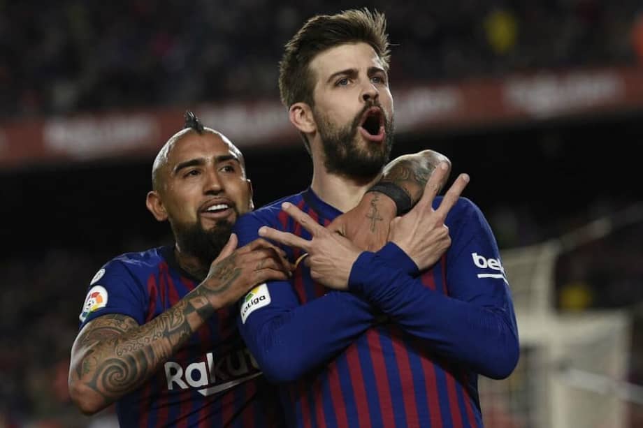 Vidal y Piqué celebran un gol con el Fútbol Club Barcelona. / AFP
