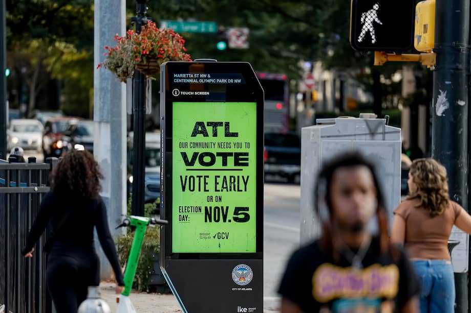 Una multitud pasa junto a un cartel que anima a votar el día de las elecciones en el centro de Atlanta, Georgia, EE. UU., el 02 de noviembre de 2024.
