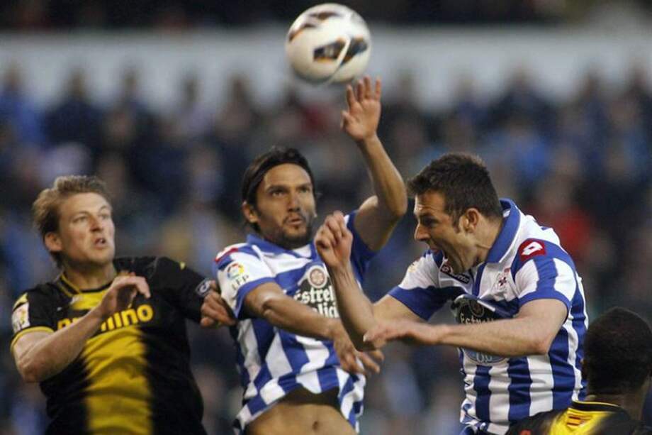 El defensa del Deportivo Carlos Marchena (d) cabecea el balón ante su compañero Abel Aguilar. / EFE