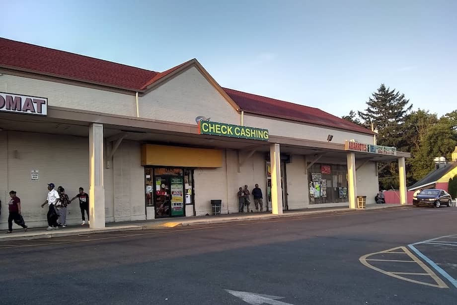 Estacionamiento el "dollar", aquí se gesta el negocio de los indocumentados, se encuentra trabajo, alquiler de vivienda, los "raiteros", se pagan los cheques cada viernes y sábado. Además, esta la casa de cambio de cheques, la lavandería, una tienda mexicana y la tienda del dólar donde se pueden adquirir artículos básicos. / Yolanda Cáceres Gutiérrez