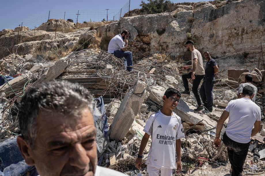 Palestinos caminan entre las ruinas de una casa demolida por las fuerzas de seguridad israelíes en la aldea de Nahalin, al suroeste de Belén, en la Cisjordania ocupada por Israel.