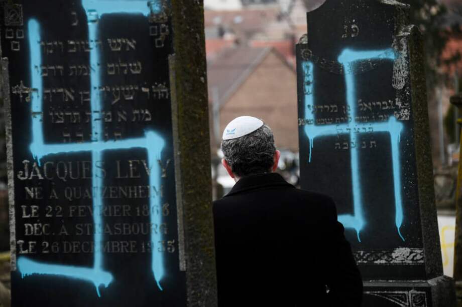 Un hombre camina frente a una de las tumbas judías vandalizadas en Francia. / AFP