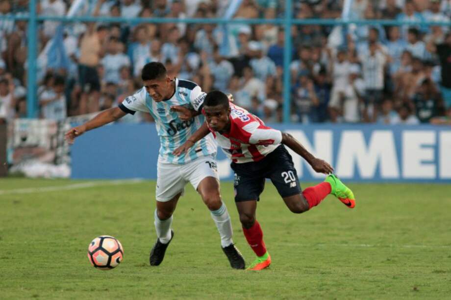 Rodrigo Aliendro , de Atlético Tucumán, disputa una pelota con Héctor Quiñones, del Júnior de Barranquilla. / AFP