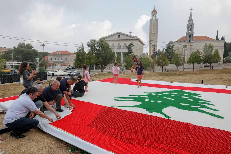 Al noreste de Beirut, unas personas trabajan en una bandera libanesa de 70 metros cuadrados, elaborada con 10.452 tapones de botella.