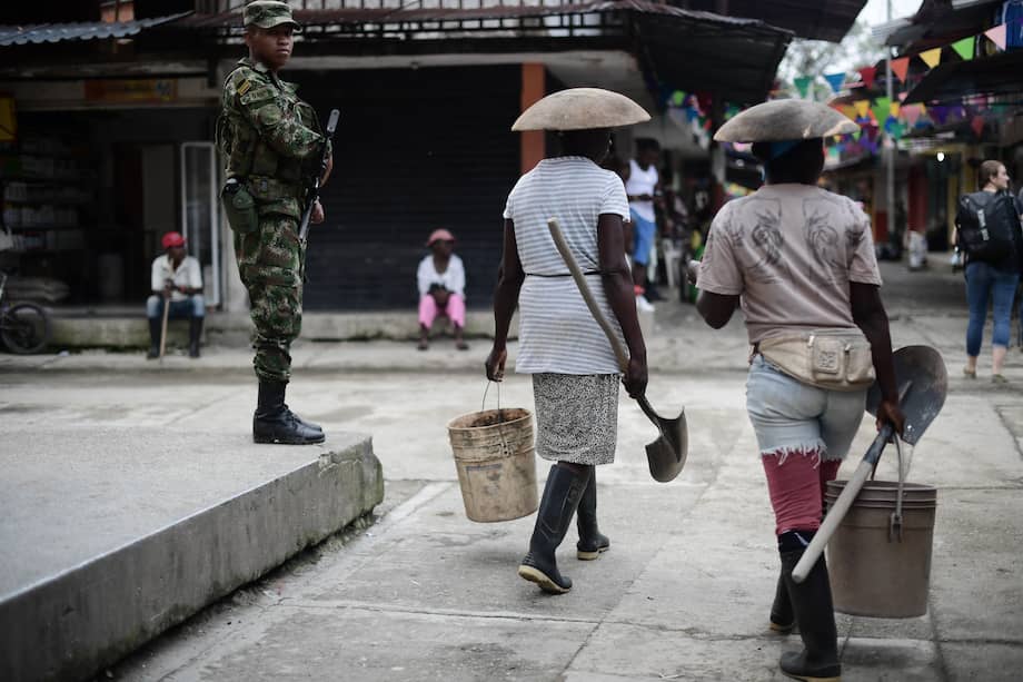 Dos mujeres barequeras van a trabajar en las retroexcavadoras que extraen oro en la vega del río López de Micay, en el Cauca. / Óscar Pérez