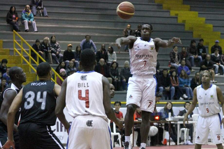 Juan Diego Tello #7 lanza ante la mirada de su compañero Rashad Bell #4.