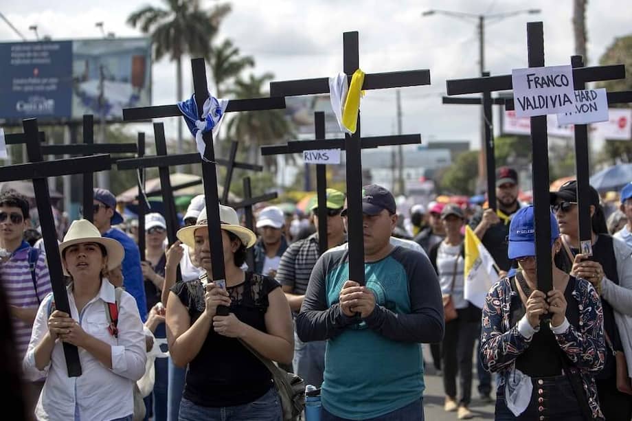 Un grupo de "autoconvocados" desplegaron banderas de Nicaragua, símbolo de las protestas contra el presidente Daniel Ortega que estallaron hace un año, durante el tradicional viacrucis penitencial del Viernes Santo. / EFE