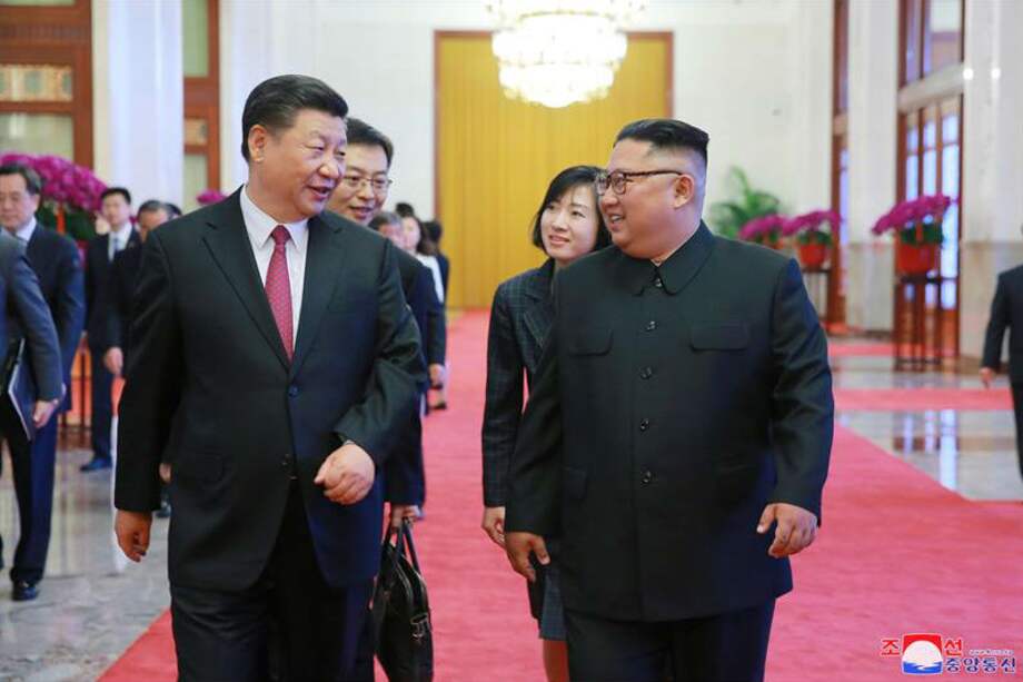 Fotografía publicada por la Agencia Central de Noticias de Corea del Norte (KCNA), que muestra al líder norcoreano Kim Jong-un (d) caminando junto al presidente chino Xi Jinping (i) durante una reunión en Pekín.