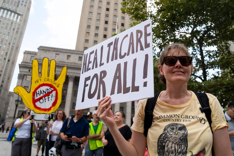 Una persona sostiene un cartel manifestando igualdad en las condiciones de salud este miércoles, en las calles de Nueva York.