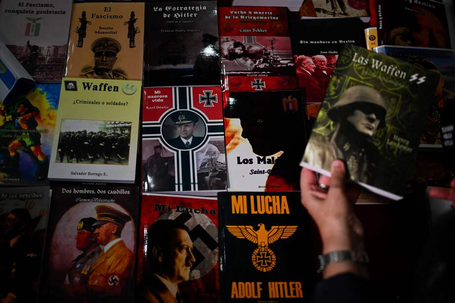 Un miembro de la Policía Federal de Argentina sostiene un libro de orientación nazi durante un allanamiento a una imprenta irregular en Buenos Aires este miércoles.