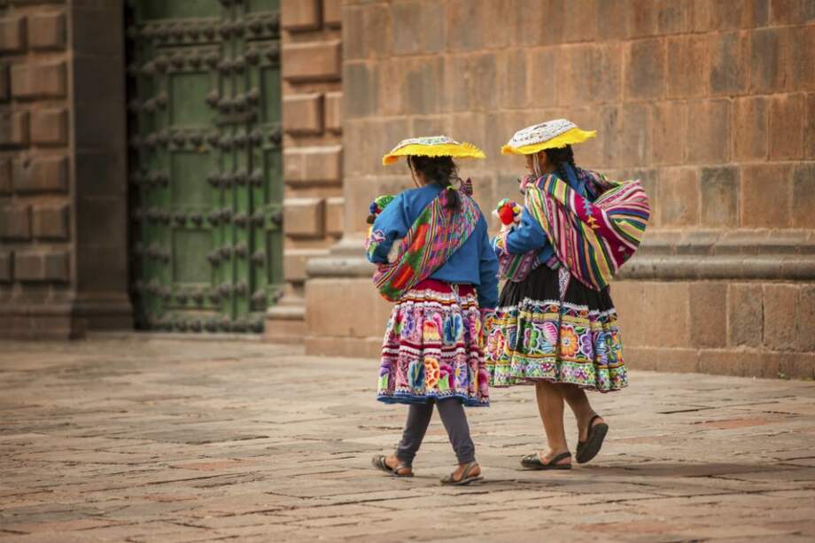 Dos indígenas caminando por la plaza central de Cusco. / iStock