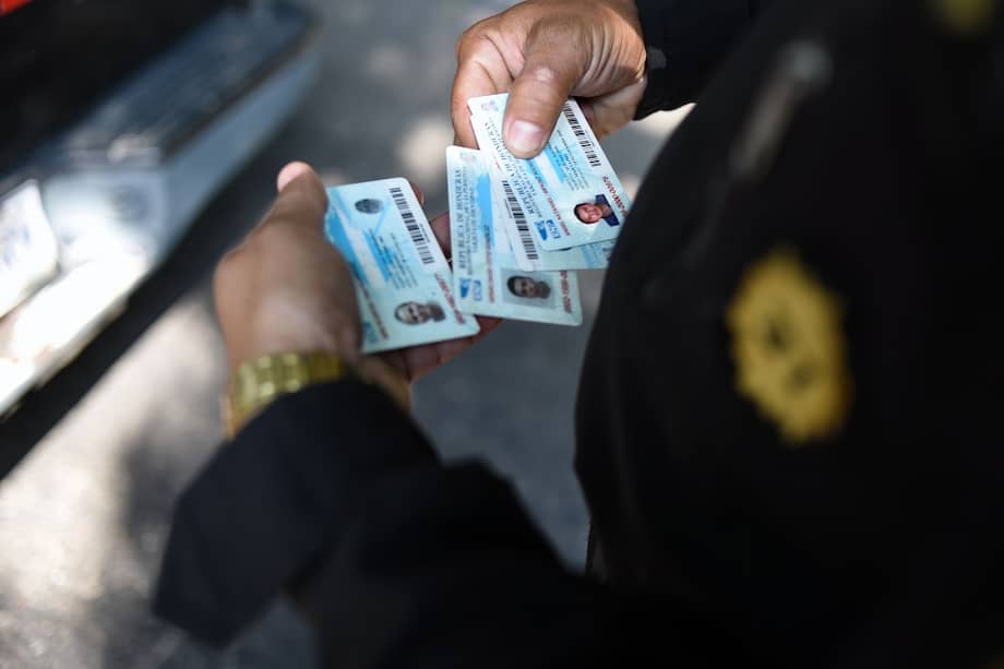 La policía guatemalteca revisa las identificaciones delos migrantes hondureños. / AFP