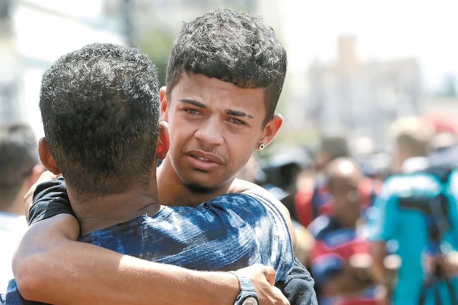 Dos estudiantes se abrazan en frente de la escuela pública Suzano, en São Paulo, tras haber sobrevivido a un tiroteo que dejó 10 muertos y ocho heridos. / AP