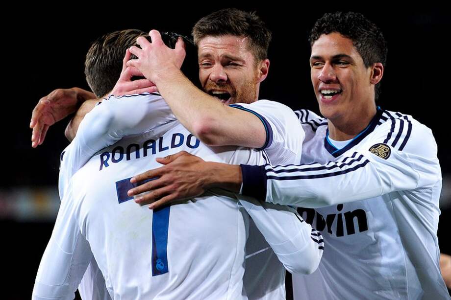 Xabi Alonso y Raphael Varane celebran con Cristiano Ronaldo uno de los dos goles que este último le marcó a Barcelona. / AFP