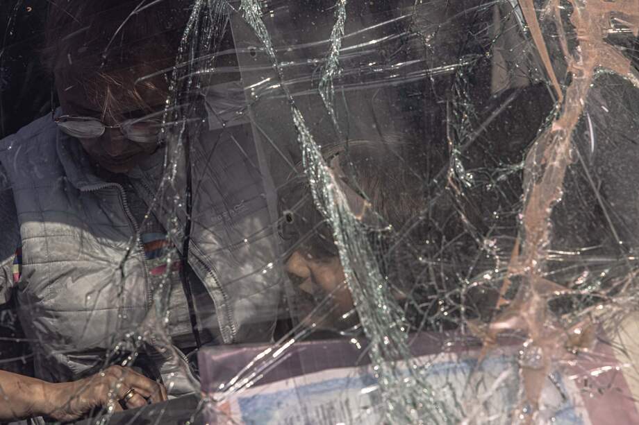 Una mujer y un niño se sientan en un automóvil con el parabrisas roto al llegar de Mariúpol al punto de evacuación en Zaporizhzhia, Ucrania, el 2 de mayo de 2022.