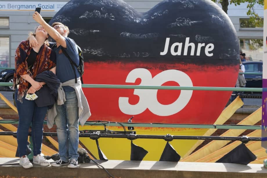 Una pareja celebra con una foto el 30 aniversario de la reunificación alemana, el 3 de octubre de 2020. / Getty Images