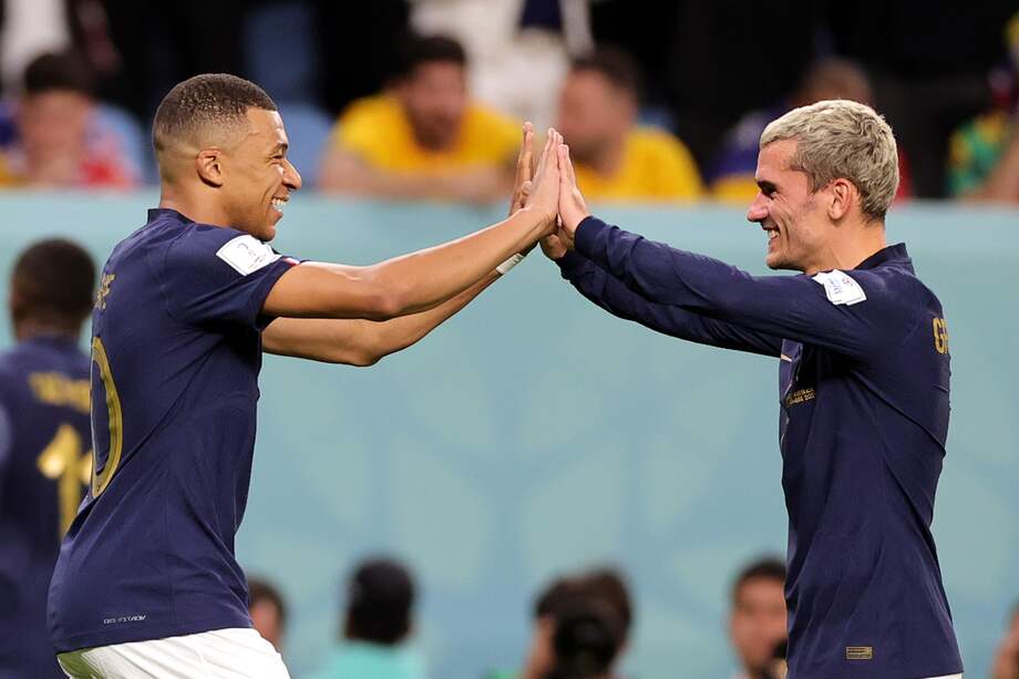 Kylian Mbappé (izquierda) choca sus manos con Antoine Griezmann.