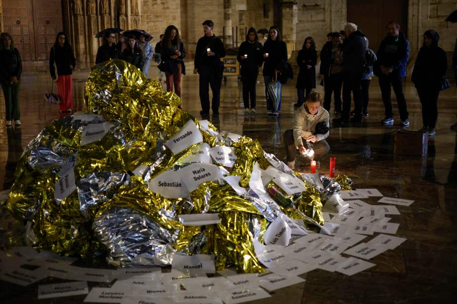 Varias personas colocan velas en un altar improvisado en el acto de denuncia y homenaje a las víctima.