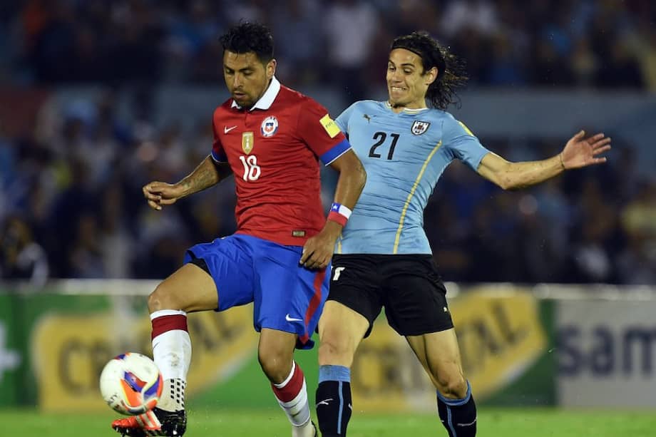 Gonzalo Jara (i) disputando una pelota con Edinson Cavani (d) durante el partido de la eliminatoria en el Centenario de Montevideo. / AFP