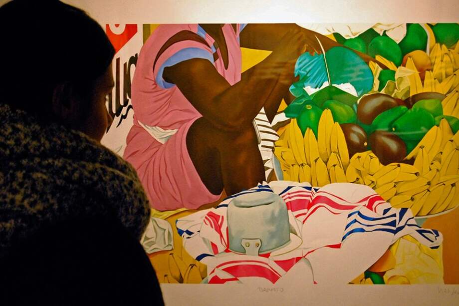 Una mujer observa una de las obras de la pintora y escultora colombiana Ana Mercedes Hoyos, que se exponen en el Instituto Cervantes de Tokio, inspiradas en el color y la vitalidad de San Basilio de Palenque. / Efe