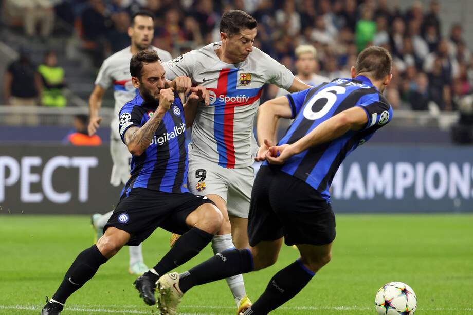 Hakan Calhanoglu (izquierda) disputa el balón con Robert Lewandowski, durante el partido de la tercera fecha de la fase de grupos de Champions entre Inter y Barcelona..