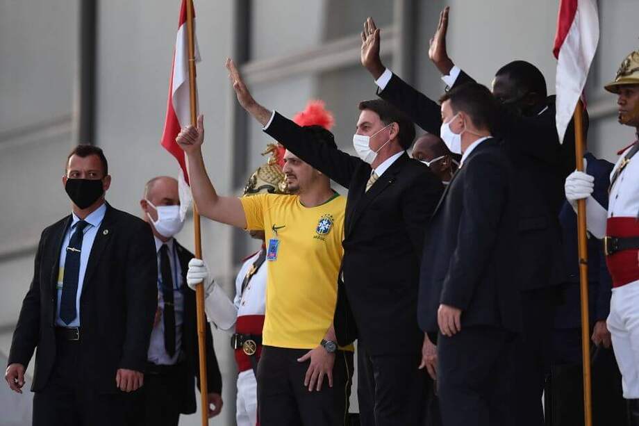 El presidente de Brasil, Jair Bolsonaro, saluda a sus partidarios frente al Palacio de Planalto en Brasilia, Brasil. / AFP