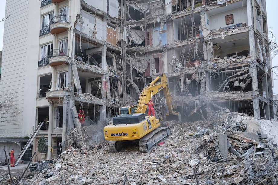Trabajadores retiran escombros de un edificio atacado por EE. UU. e Israel en Andarzgu, Teherán.