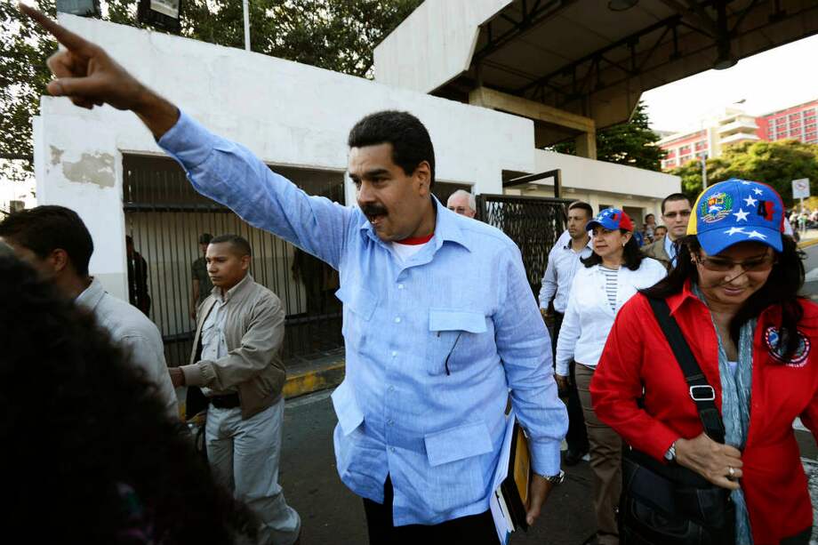 El vicepresidente venezolano, Nicolás Maduro, saluda a los seguidores de Chávez a las afueras del hospital militar. / AFP
