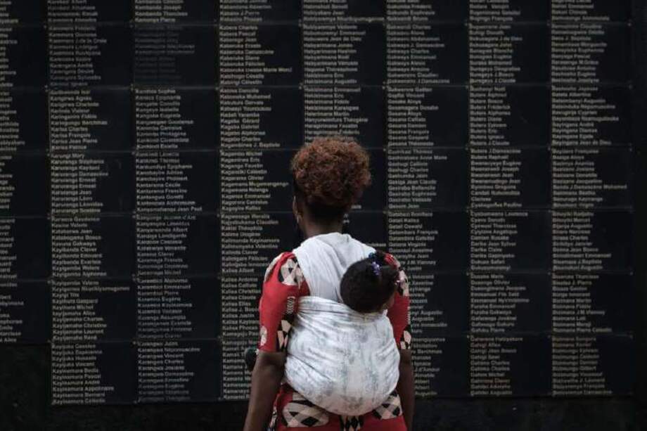 Una mujer lee los nombres de las cerca de 800.000 víctimas del genocidio en Ruanda, hace 25 años. / AFP