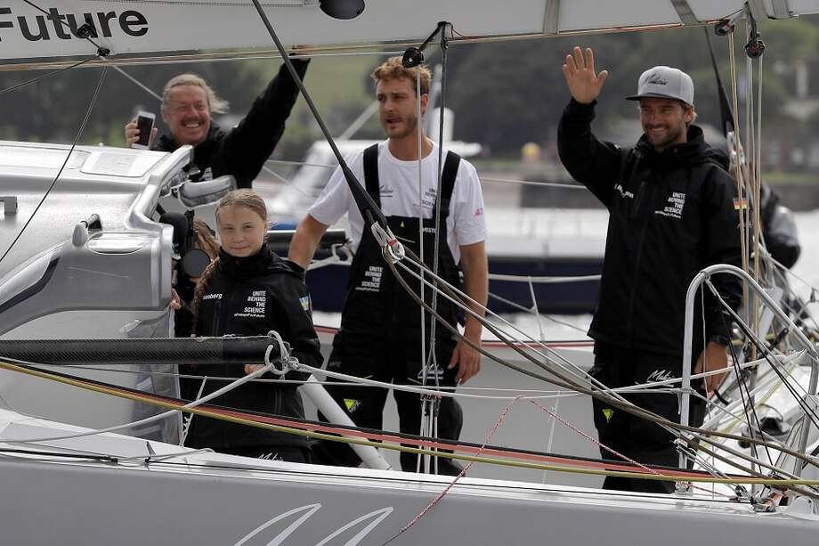 El artista sueco Svante Thunberg; su hija, la activista climática Greta Thunberg; el hijo menor de Carolina de Mónaco, Pierre Casiraghi, y el navegante alemán Boris Herrmann saludan a bordo del Malizia II mientras abandonan el puerto de Plymouth (Reino Unido), este miércoles. / EFE