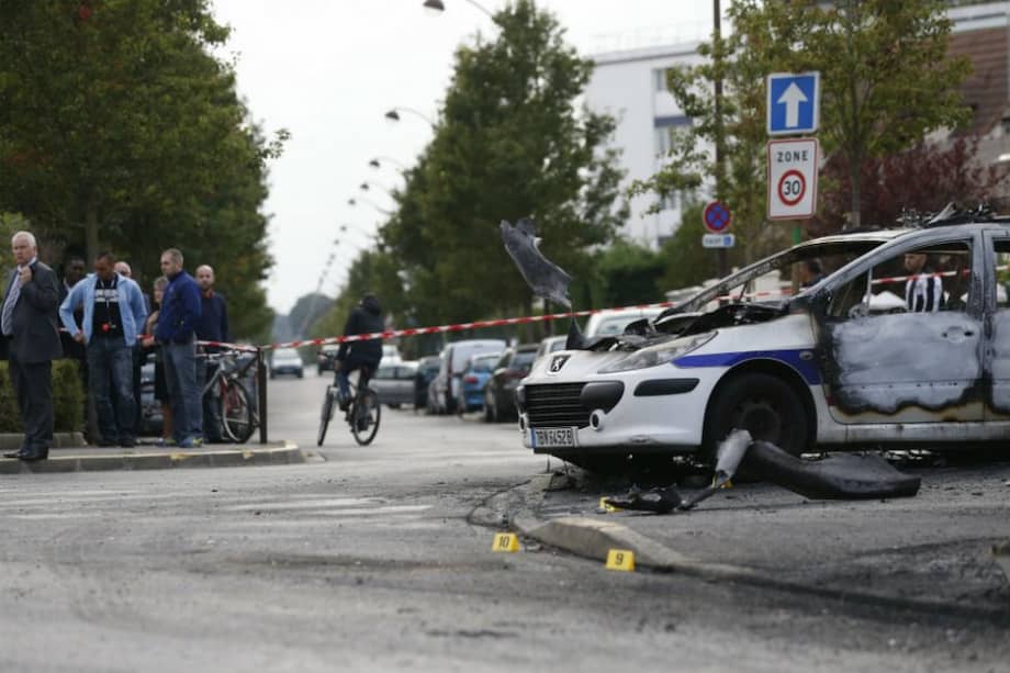 Así quedaron las patrullas de la Policía tras el ataque. Ambas calcinadas. / AFP