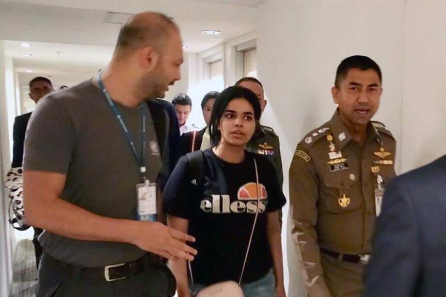 La joven saudí, Rahaf Mohammed Al-Qunun, conversa con el jefe de la policía de inmigración de Tailandia, Surachet Hakparn, y un trabajador de ACNUR antes de abandonar el aeropuerto Suvarnabhumi en Tailandia el lunes, 7 de enero de 2018. / EFE.