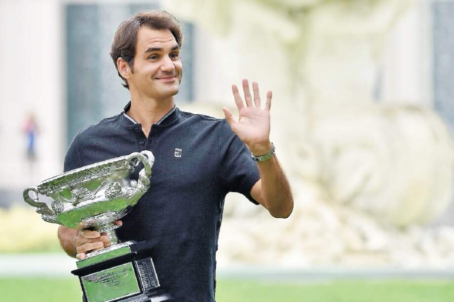 El suizo Roger Federer exhibe orgulloso su copa del Abierto de Australia. / AFP
