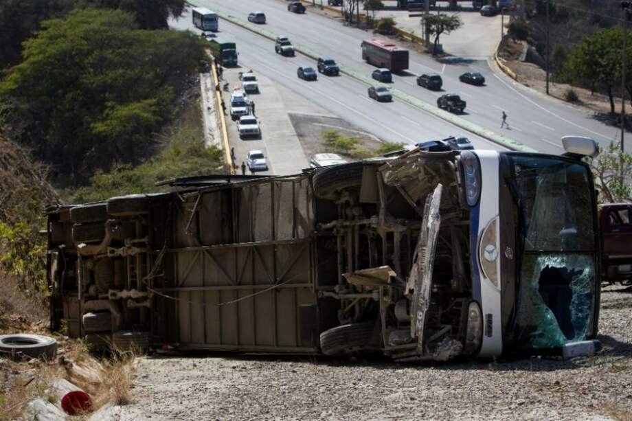 Un grupo de operadores de grúa ponen un gancho al autobús que trasladaba al equipo argentino Huracán. Foto: EFE