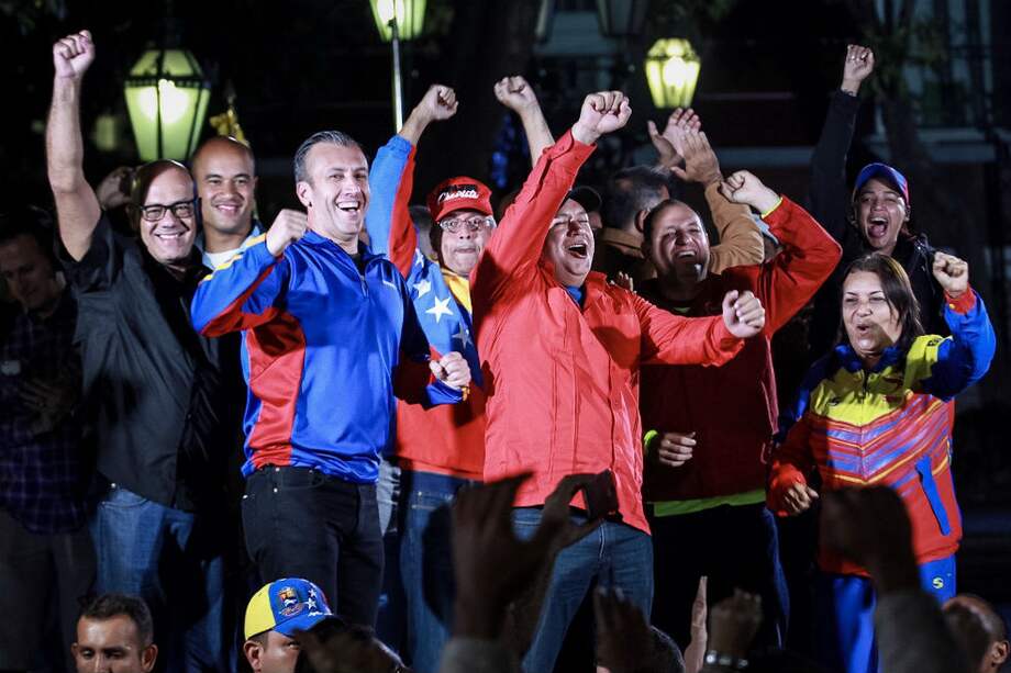El vicepresidente económico y ministro de Industrias de Venezuela, Tareck el Aissami (azul izquierda) en una celebración chavista en Caracas. / AFP
